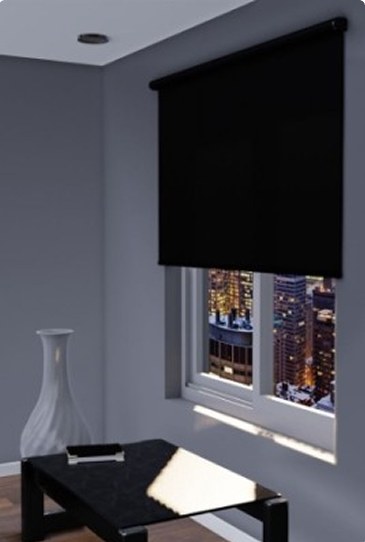 Blackout roller shade lowered over a city-view window in a modern living room