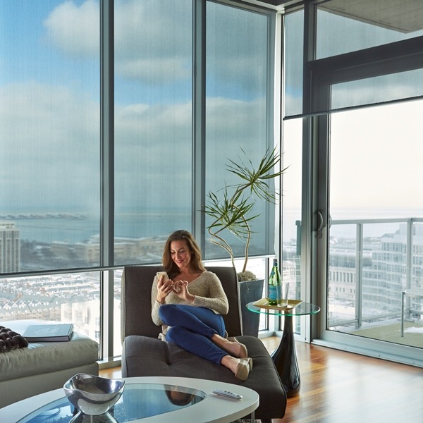 Light-filtering shades in a home office with floor-to-ceiling glass