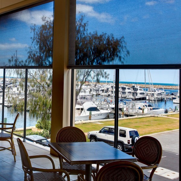Motorized exterior shades on a terrace with glass railings