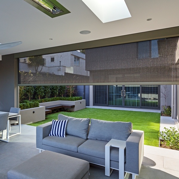 Outdoor shades lowered over a poolside seating area